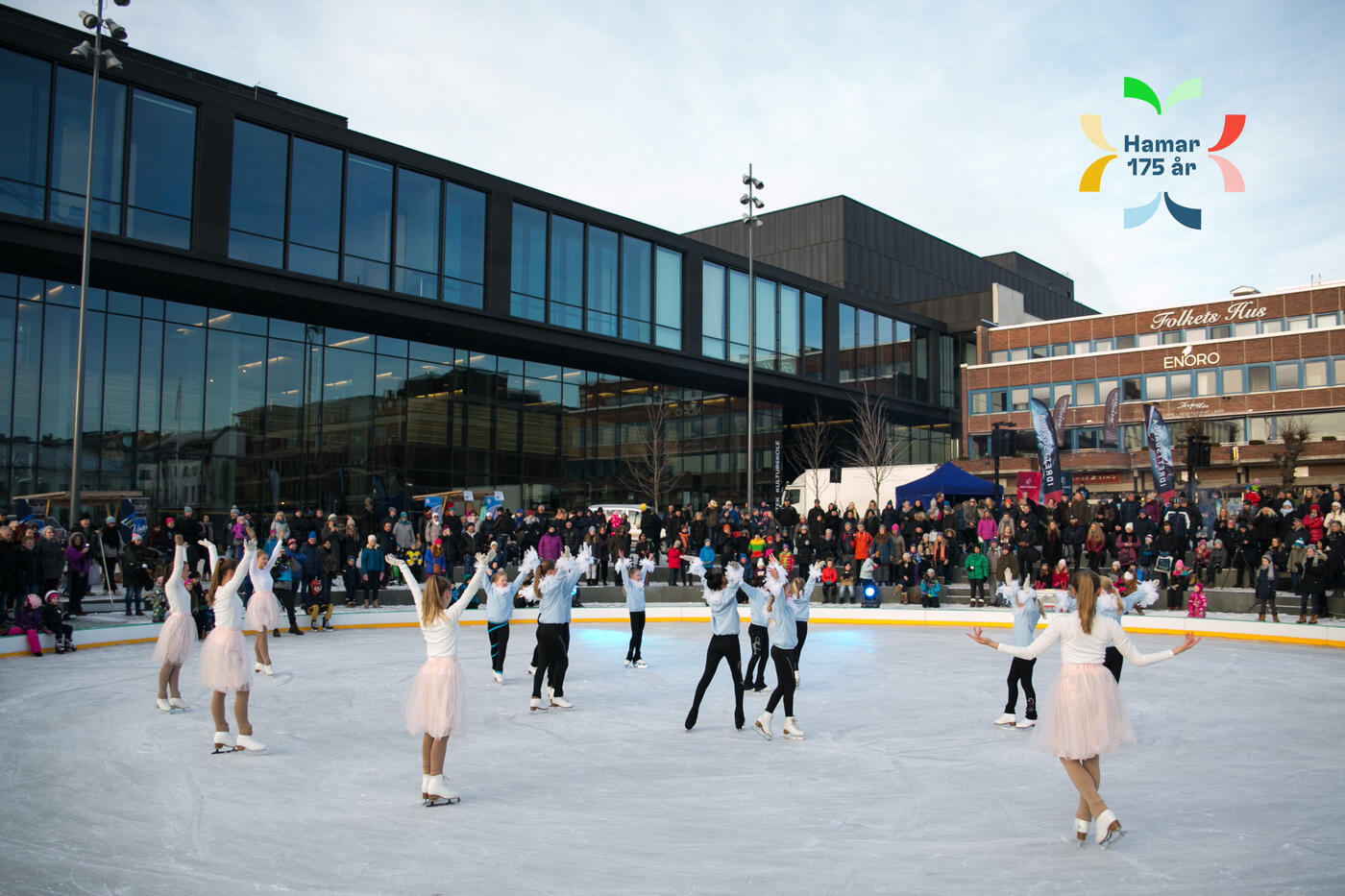 Isdansere på stortorget og jubileumslogo